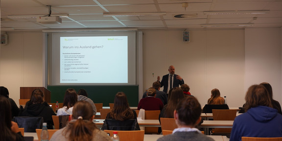 Studierende mit dem Rücken zur Kamera auf einer Informationsveranstaltung