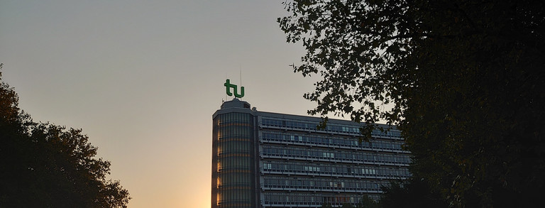 Blick auf Sonnenuntergang am Mathe-Gebäude mit Bäumen im Vordergrund