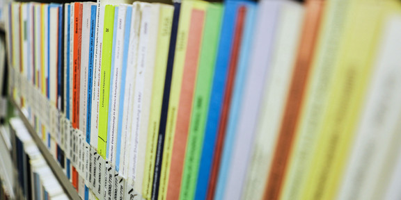 Dissertations in library Books with the inscription dissertation on a bookshelf in the library.